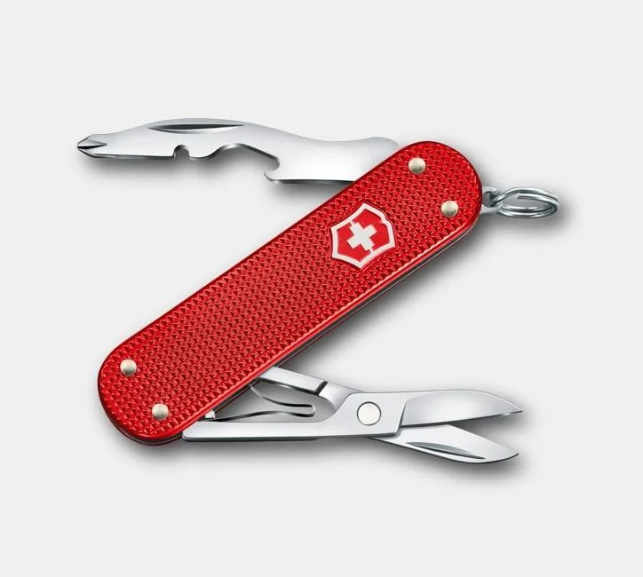 A red Victorinox Swiss Army knife with a textured Alox handle is shown with its pliers and a bottle opener tool deployed.